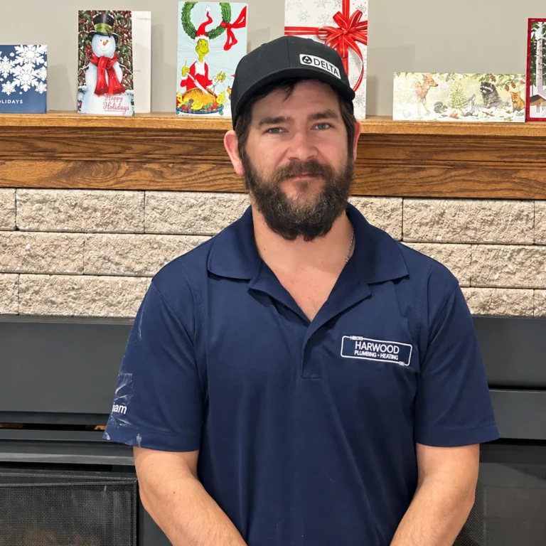 Adam Harwood, owner, wearing his Harwood work shirt beside holiday cards on the mantel